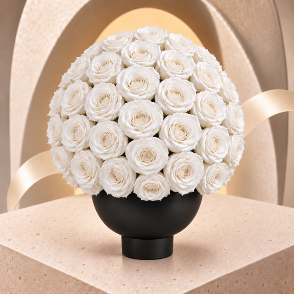 The Eternal Sphere Vase with a rounded dome of white preserved roses.