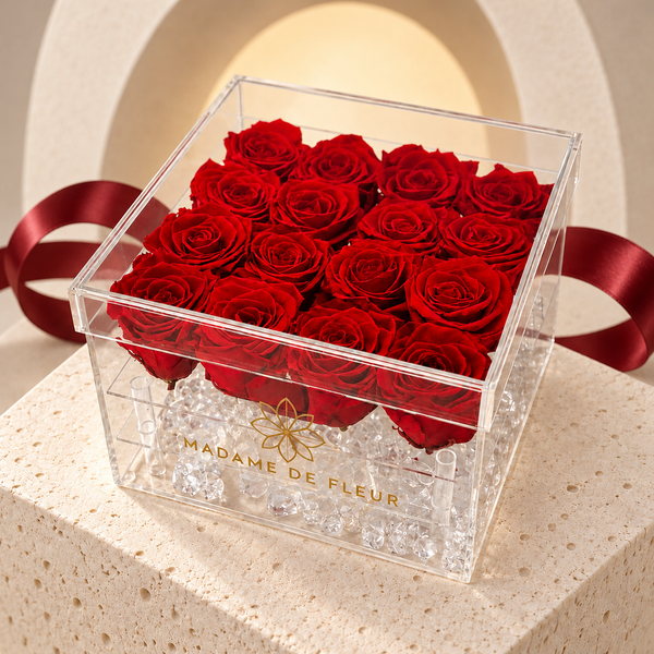 Medium Acrylic Square Box with preserved roses and dark-red ribbon against a cream arch background.