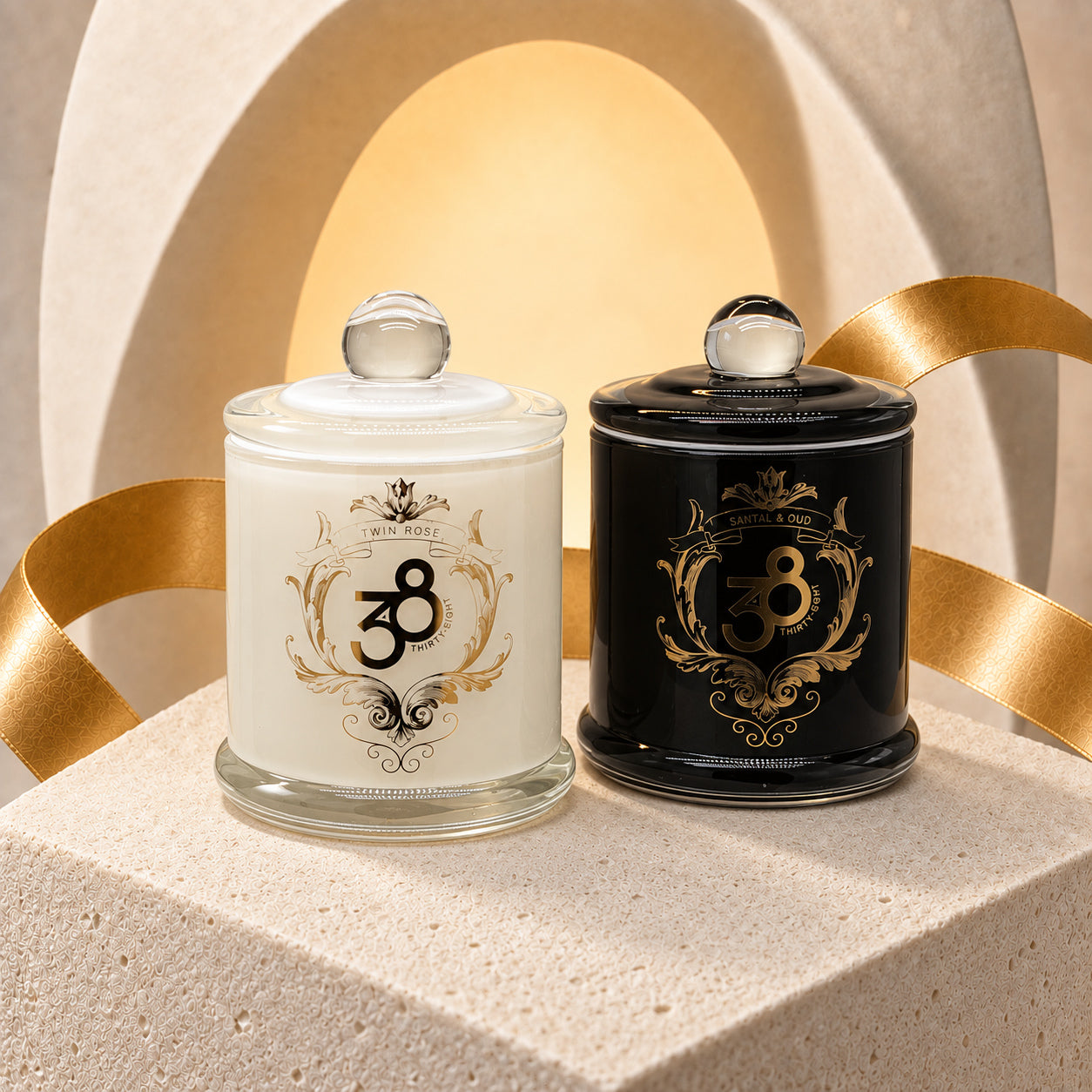Bloom & Desire two-candle set with white Twin Rose and black Santal & Oud candles, ornate gold-toned details and round-knobbed lids