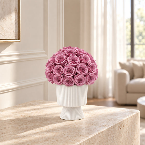 Lumiere mauve preserved rose arrangement displayed on a console table
