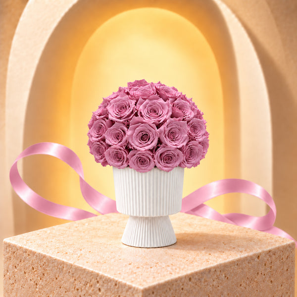 Lumiere mauve preserved roses in a white fluted pedestal vase