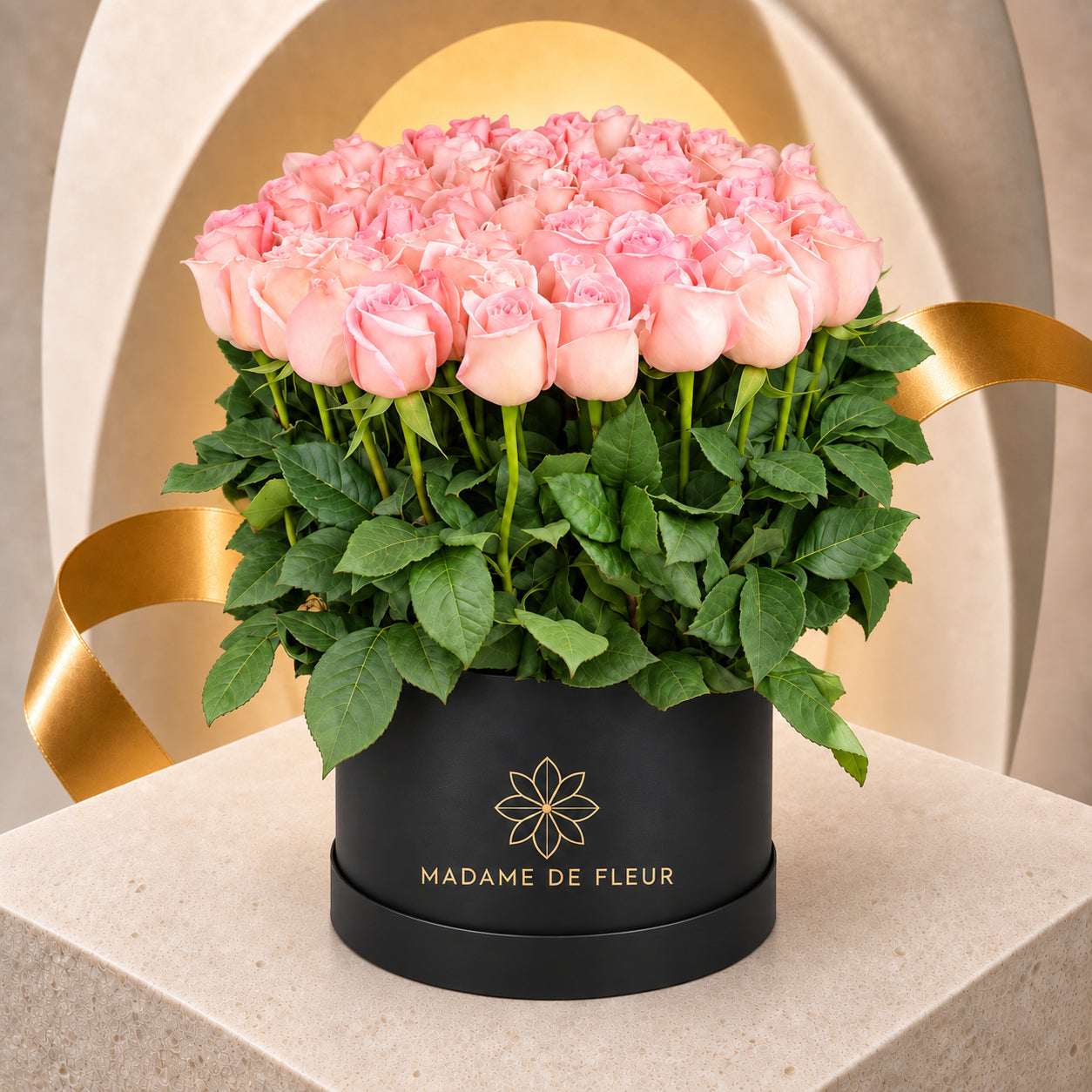 Fifty blush-pink fresh roses standing upright with green foliage in a black MADAME DE FLEUR box.